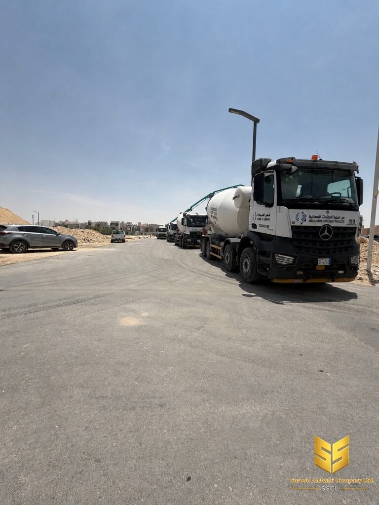 صف من شاحنات الخرسانة الجاهزة متوقف بجوار موقع إنشائي في الرياض