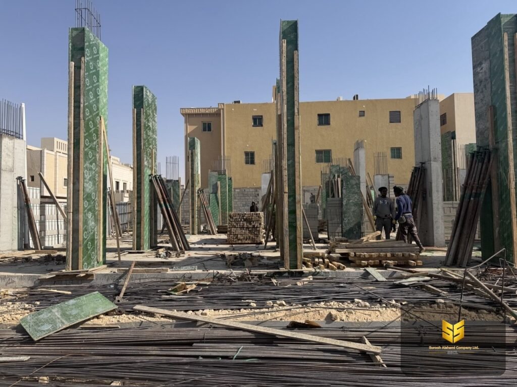 قوالب خشبية خضراء مثبتة حول الأعمدة الخرسانية داخل مشروع سكني في الرياض