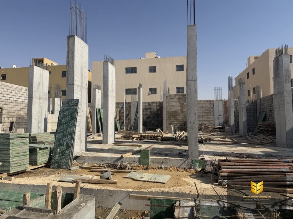 مشهد عام لأعمدة خرسانية وجدران بلوك ومواد شدات داخل مشروع سكني في الرياض