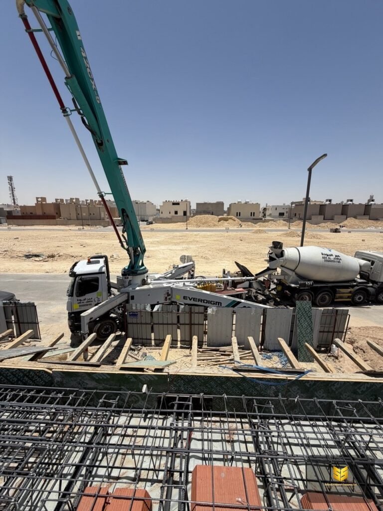 مضخة خرسانة وخلاطة جاهزة بجوار سقف مسلح قيد التجهيز في مشروع بالرياض