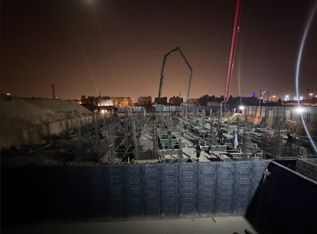 مضختا خرسانة بذراعين ممتدين فوق مشروع إنشائي أثناء تنفيذ الصب ليلًا في الرياض